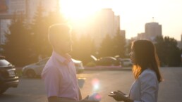 two adults speaking in a city